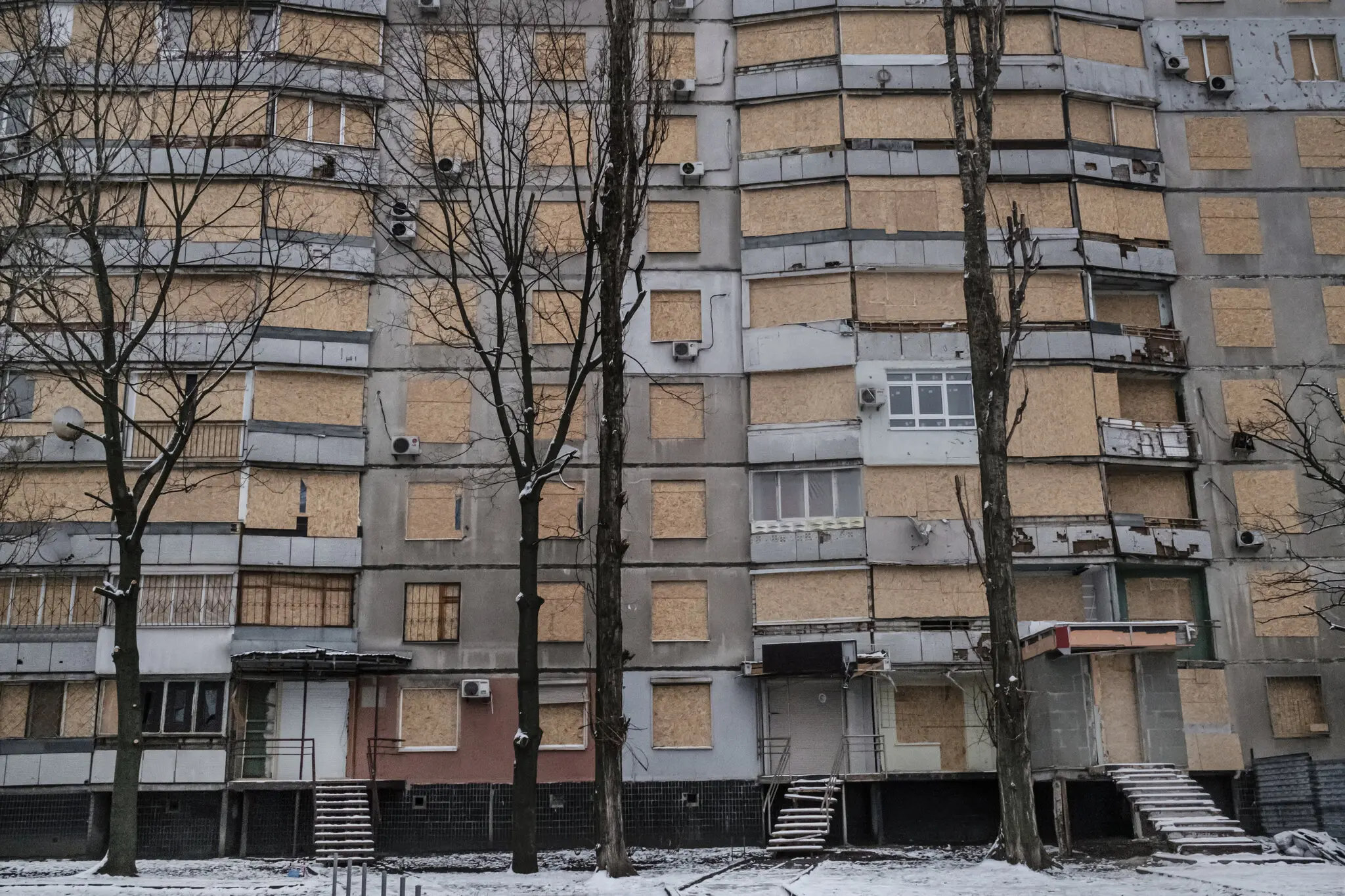 Забиті дошками квартири у багатоповерхівці 8 грудня після нещодавніх російських ударів на Салтівці, Україна.